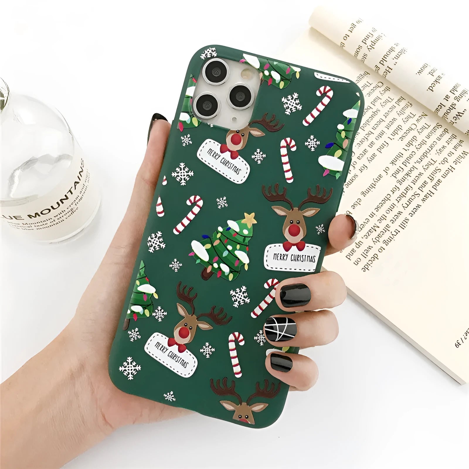 Green iPhone case with a cartoon Christmas tree and elk design on a flexible TPU back cover.