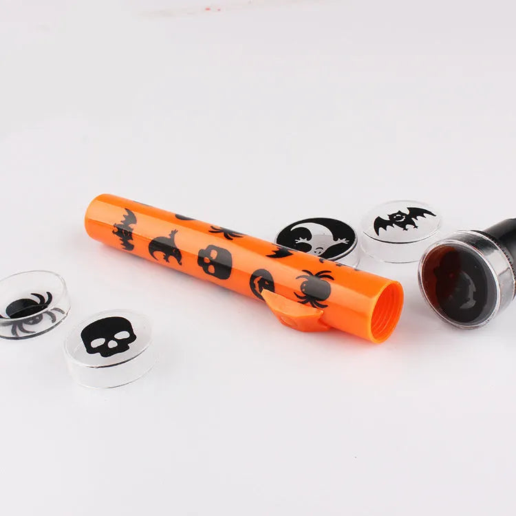 Orange metal pumpkin skull flashlight projection lamp on a plain background