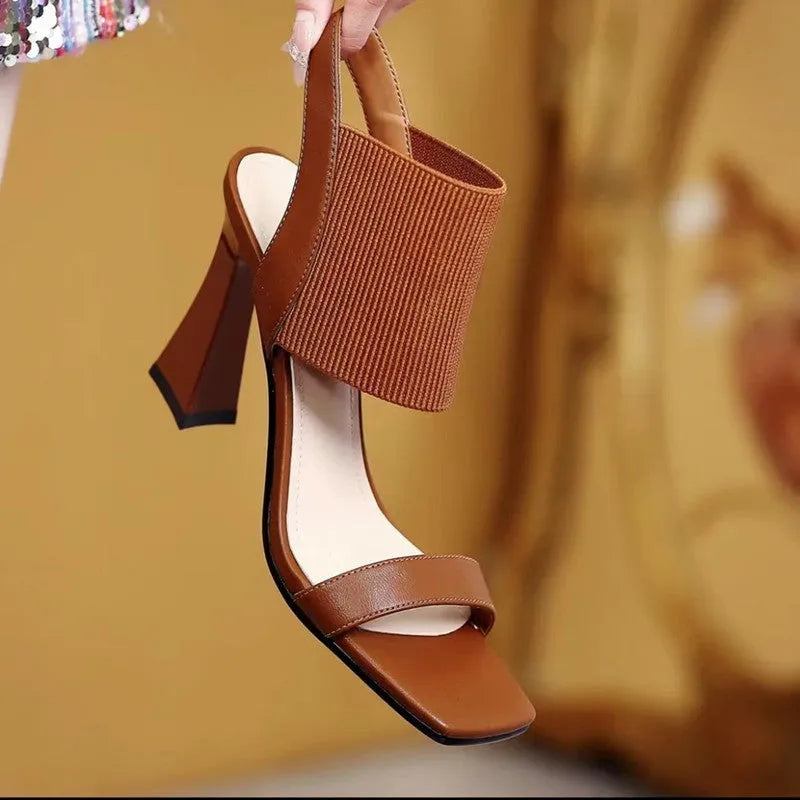 Women's black high heel sandals with an elastic strap across the foot and a rubber sole