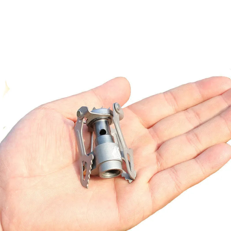 Compact portable propane gas camping stove with one-piece steel body and cast iron burner.