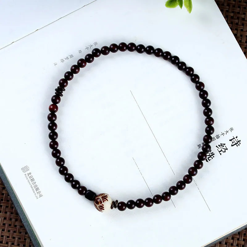 Rosewood bracelet with knitted construction showing floral carving details and 10mm diameter