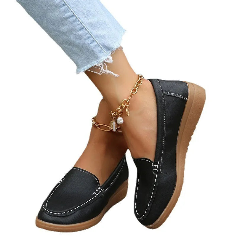 Women's black PU leather slip-on loafers with a round toe and flat rubber sole.