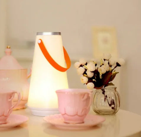 White rechargeable LED bedside lamp with adjustable brightness on wooden table