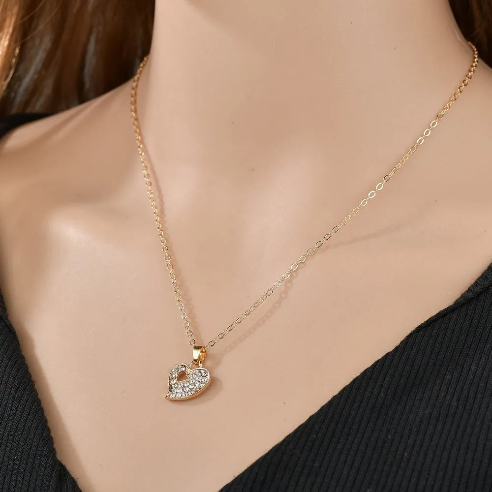 Women's gold tone alloy jewelry set with matching earrings, pendant and bracelet featuring love patterns