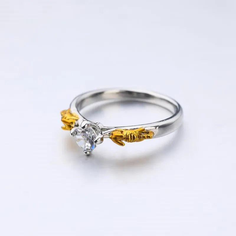 Black gold finished copper ring with a detailed crown motif and crystal settings on a finger.