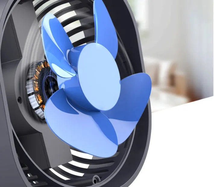Pink USB rechargeable desk fan with rotating head on a wooden desk.