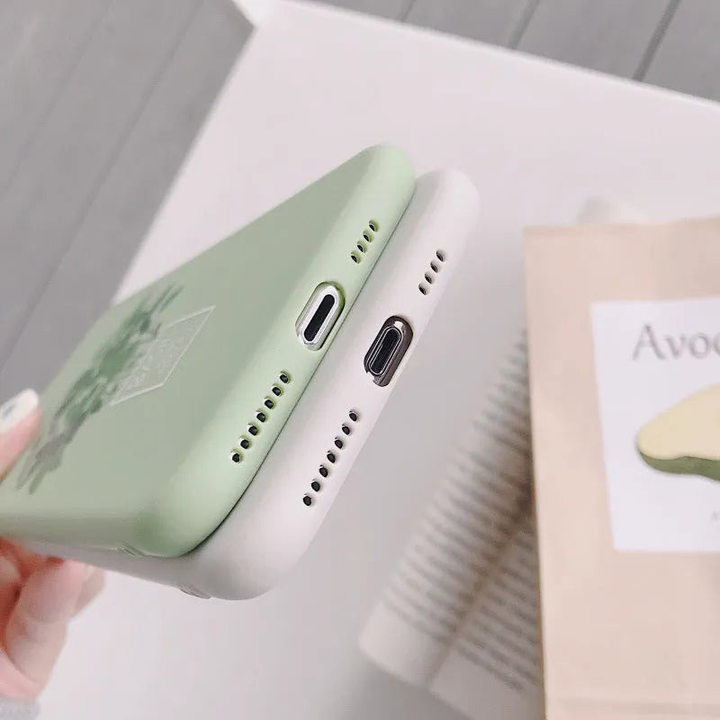 White silicone iPhone case with a detailed painted plant design on the back, showing the smooth texture and enclosed edges.