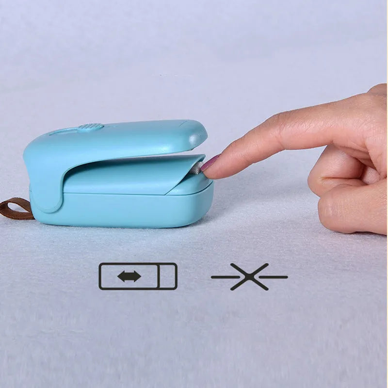Mini hand pressure heat sealing machine in blue on white background, 10cm long ABS and metal body