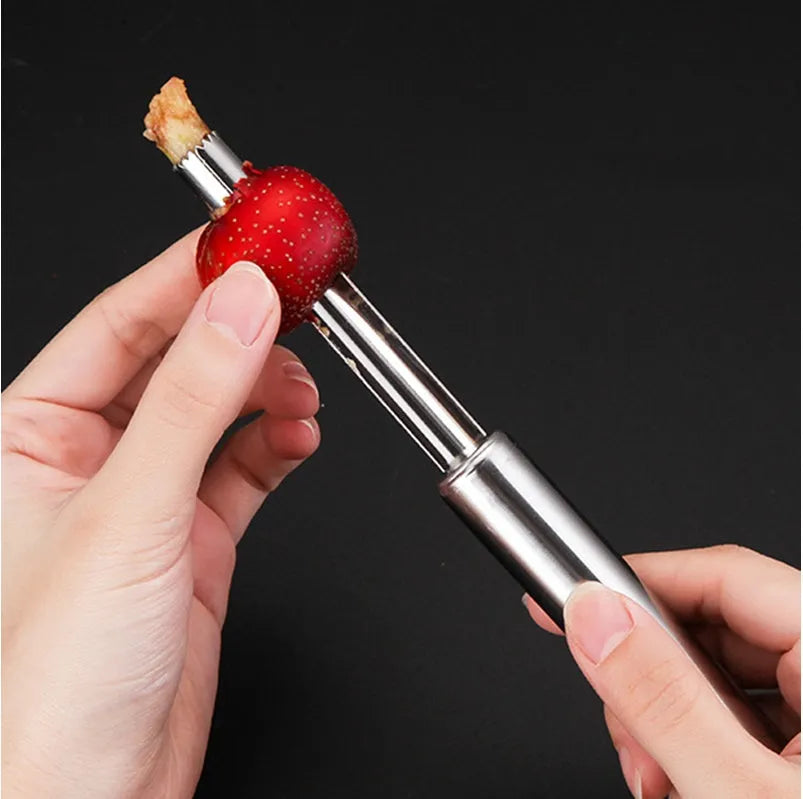 Stainless steel pineapple corer slicer with black plastic handle on a kitchen worktop.
