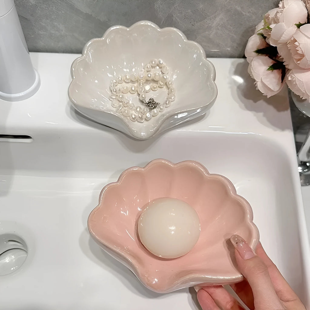 White plastic shell-shaped soap dish on bathroom countertop