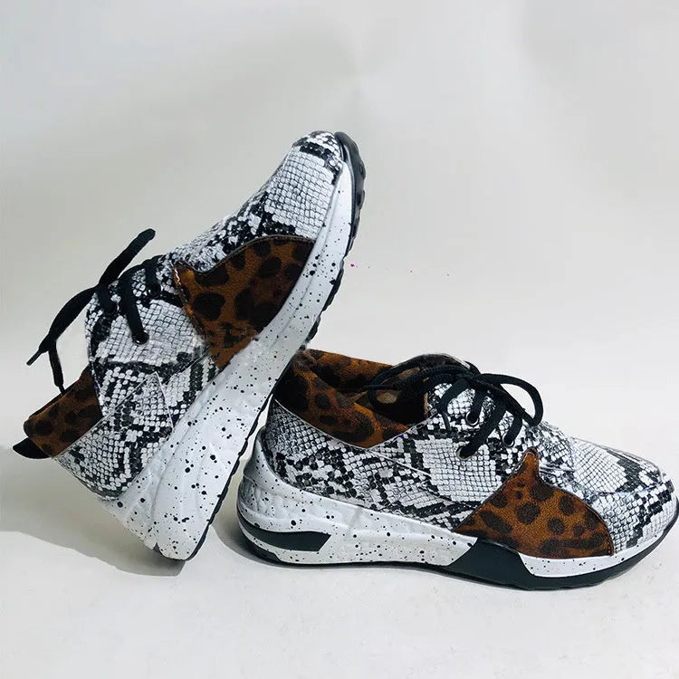 Women's casual wedge heel sneakers in suede, showing round toe and low-cut profile on a wooden floor.