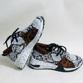 Women's casual wedge heel sneakers in suede, showing round toe and low-cut profile on a wooden floor.
