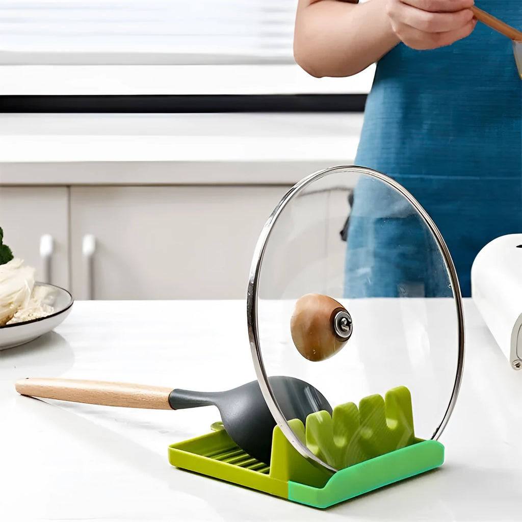 Green silicone 4-hole kitchen spatula holder with chopsticks and spoon on clean countertop