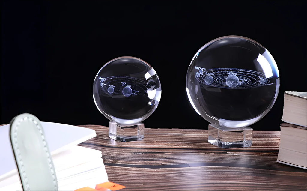 Solar system laser-engraved inside K9 crystal ball on a wooden desk beside an LED base