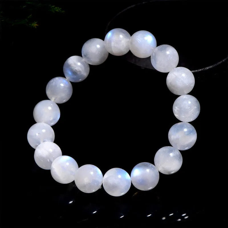 Natural blue moonlight round bead moonstone bracelet on a wrist, showing polished stones.