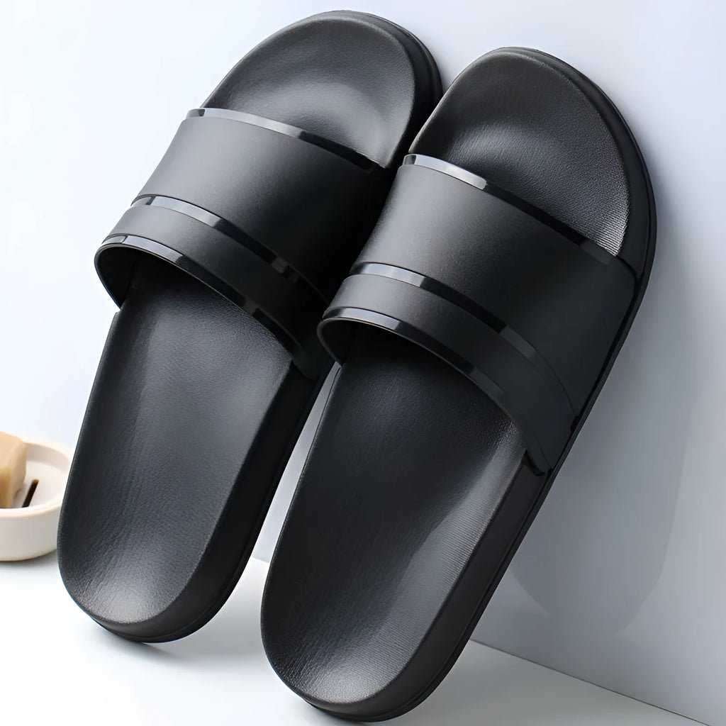 Unisex non-slip bathroom slippers in non-woven fabric with thick sole, available in black or white, sizes S to XXL