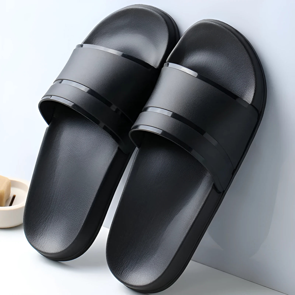 Unisex non-slip bathroom slippers in non-woven fabric with thick sole, available in black or white, sizes S to XXL