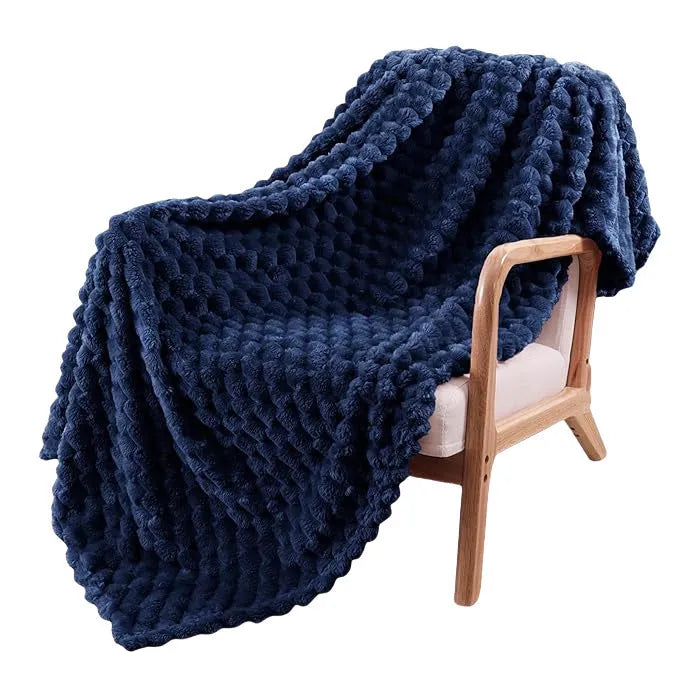 Soft camel-coloured plaid children's blanket folded on a wooden chair.