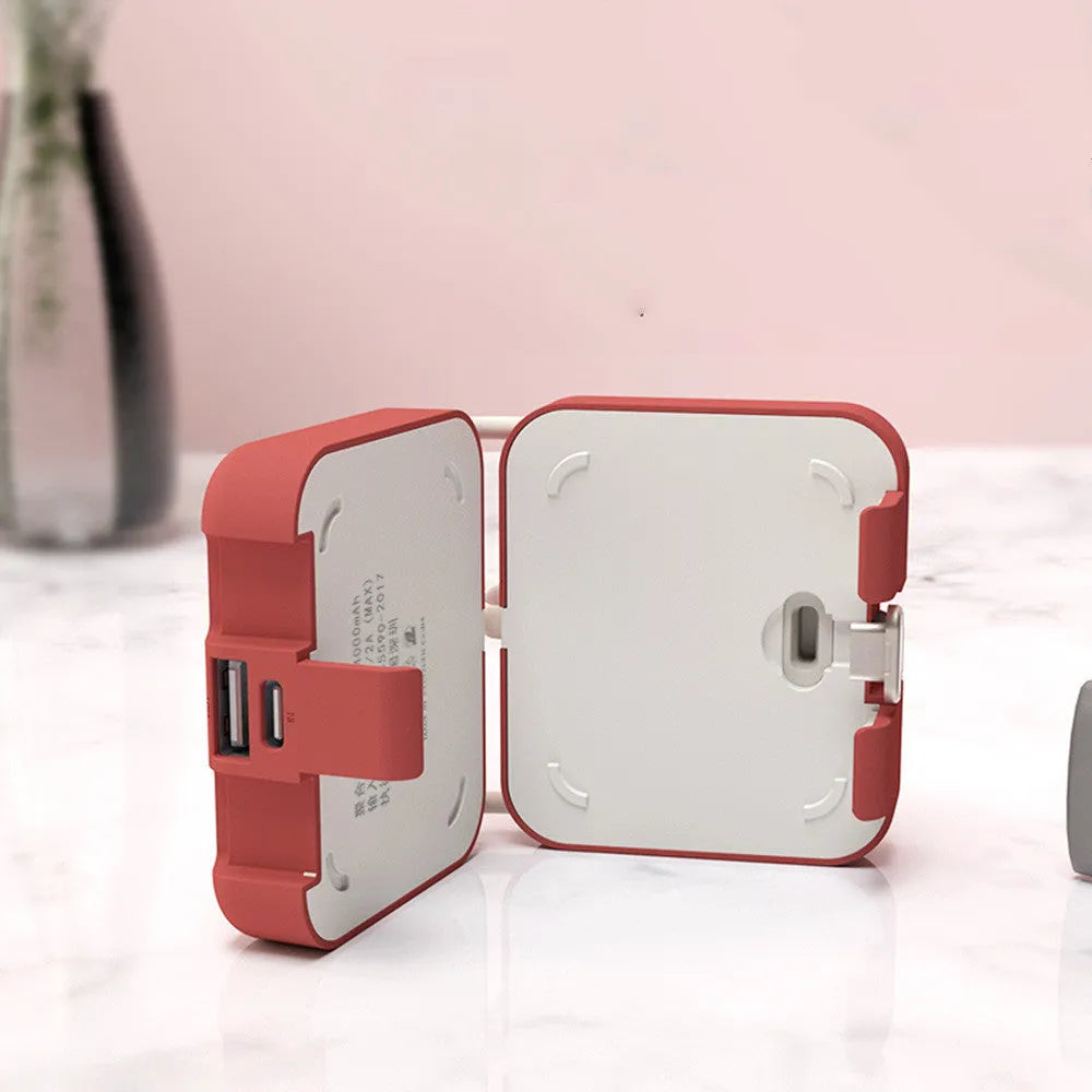 Handbag clip-on portable power bank in blue, shown charging a phone and functioning as a stand.
