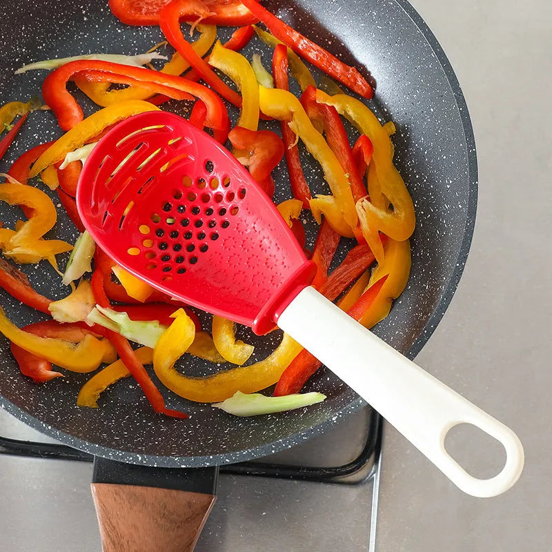 Red and black plastic multifunctional slotted cooking spoon with serrated edges for mashing and grinding.