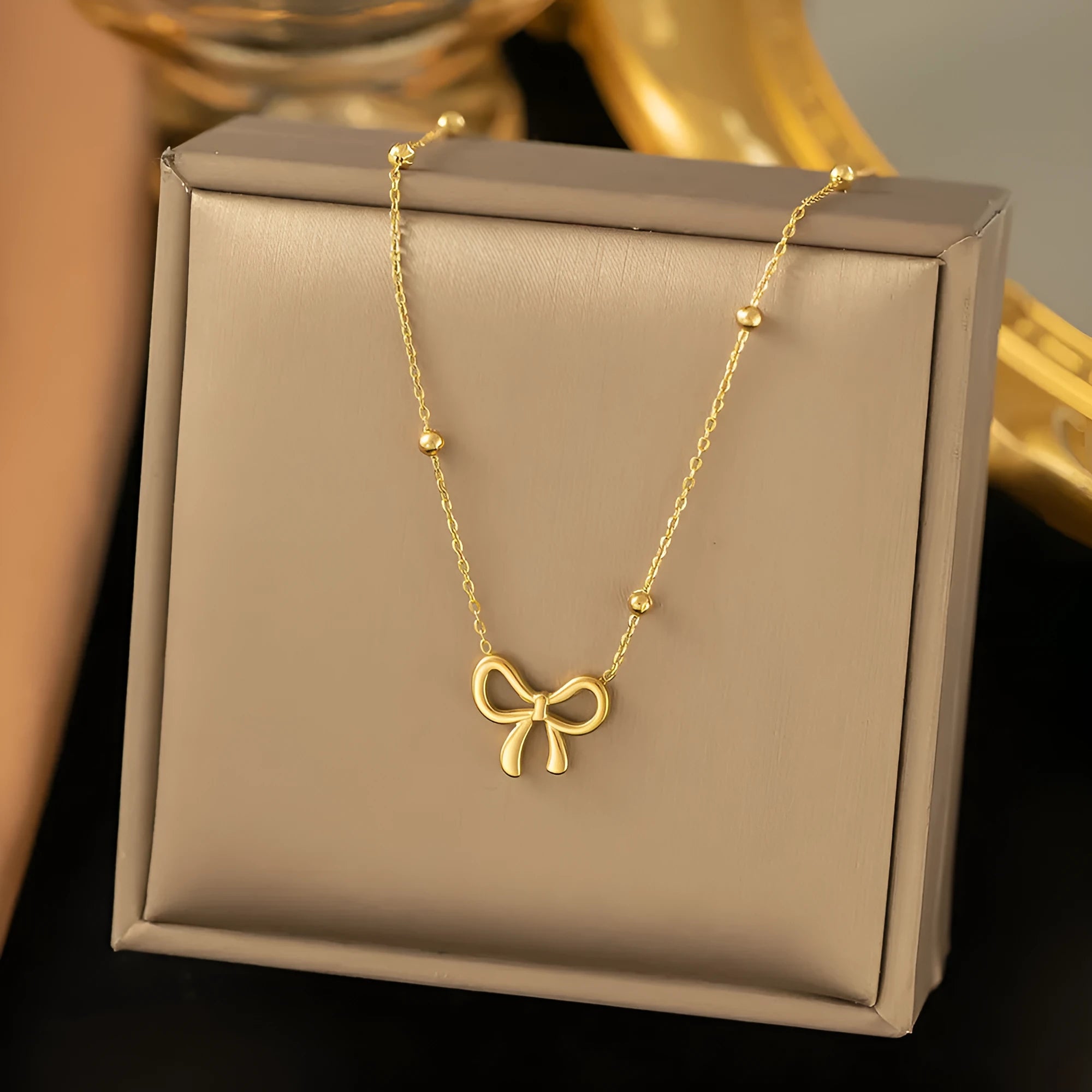 Gold electroplated bow necklace on titanium steel chain with adjustable 41-50cm length
