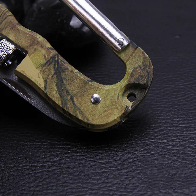Camouflage multifunctional carabiner with knife, saw, and LED light on a black background