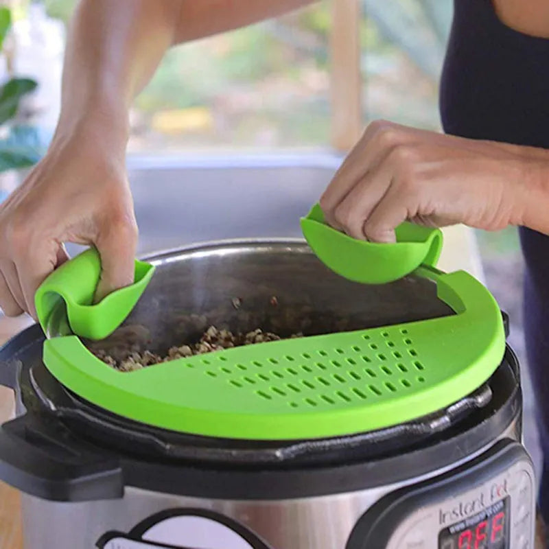 Black silicone food oil drainer clipped onto a pressure cooker liner for draining liquid