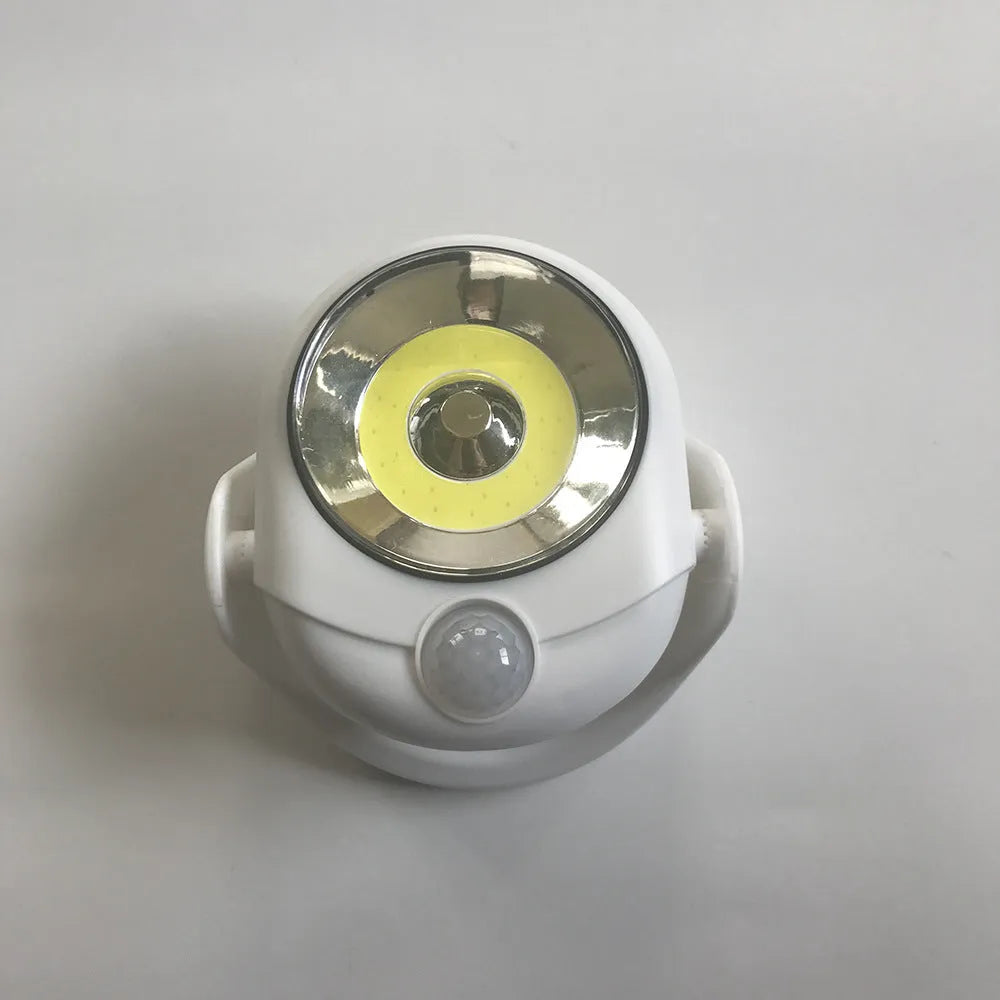 White Atomic Angel induction lamp with compact ABS housing on charging base.
