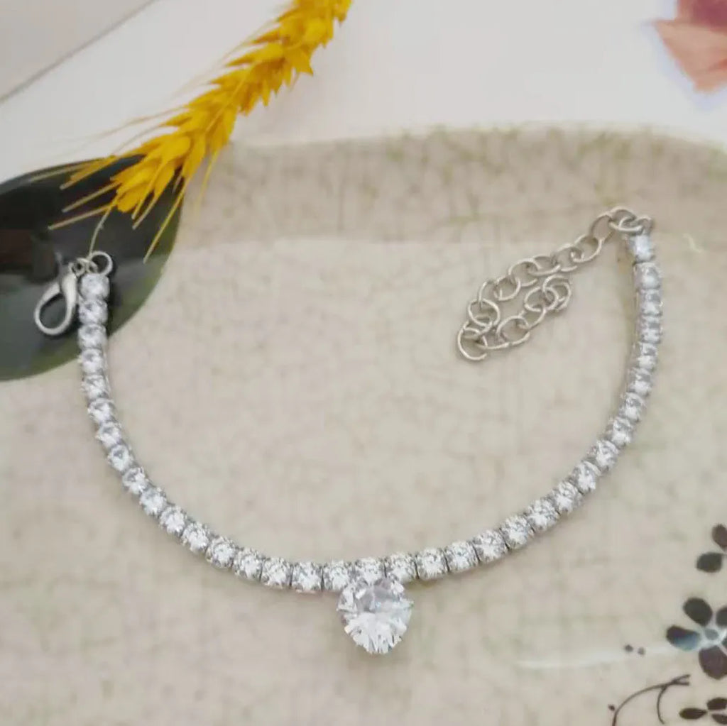 Gold heart-shaped rhinestone dog collar on a white background with an adjustable chain.