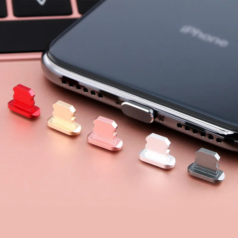 Aluminium alloy iPhone charging port dust plug in various colours on a dark background