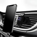 Matte black car phone holder clipped onto a car air vent, holding a smartphone.