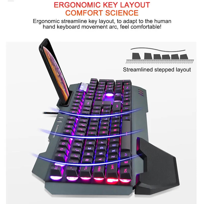Black wired gaming keyboard with RGB backlight, phone holder, pen tray, and magnetic wrist rest on a desk