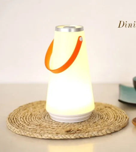 White rechargeable LED bedside lamp with adjustable brightness on wooden table