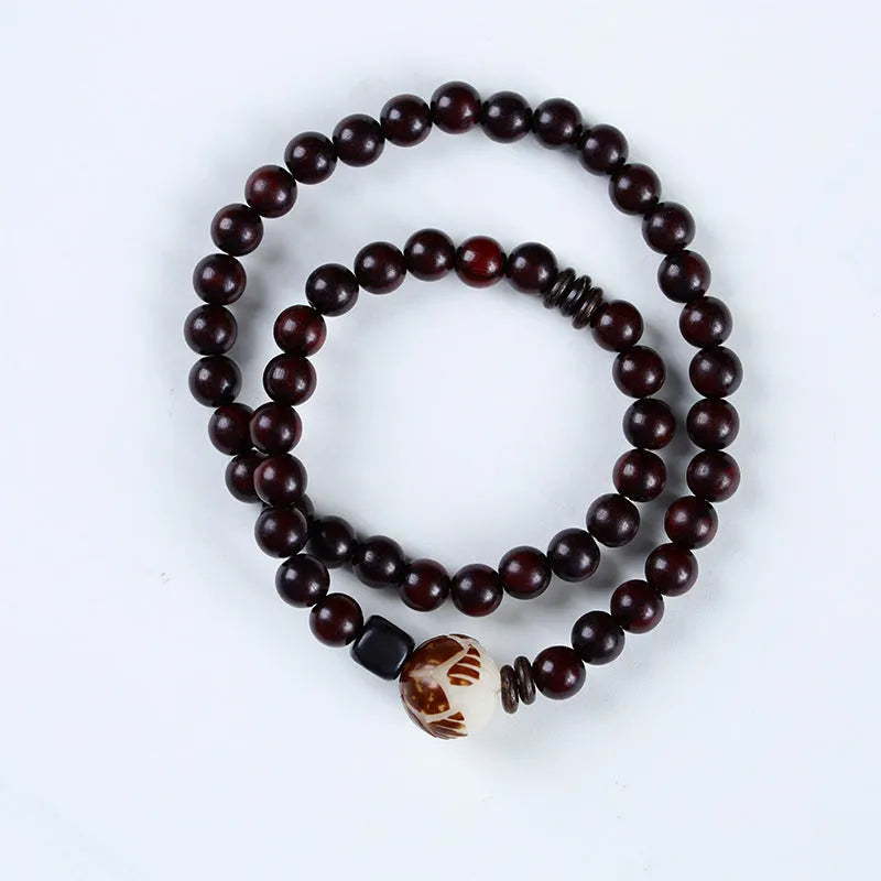 Rosewood bracelet with knitted construction showing floral carving details and 10mm diameter