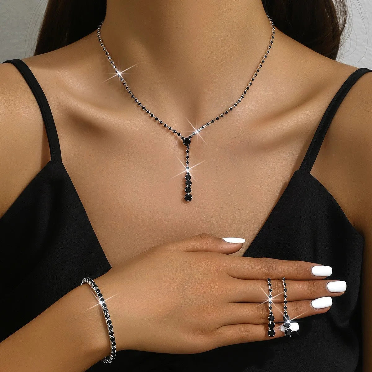 Women's three-piece bridal jewellery set showing earrings, necklace and bracelet with rhinestone heart-shaped pendant