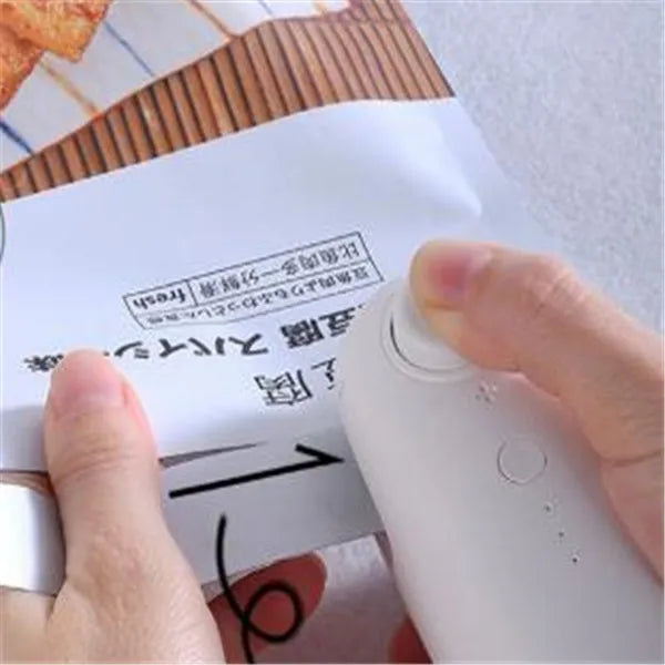 Mini hand pressure heat sealing machine in blue on white background, 10cm long ABS and metal body