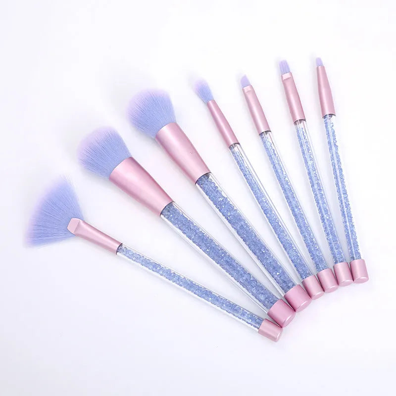 Set of 7 makeup brushes with pink handles, black bristles, and long plastic handles on a light background