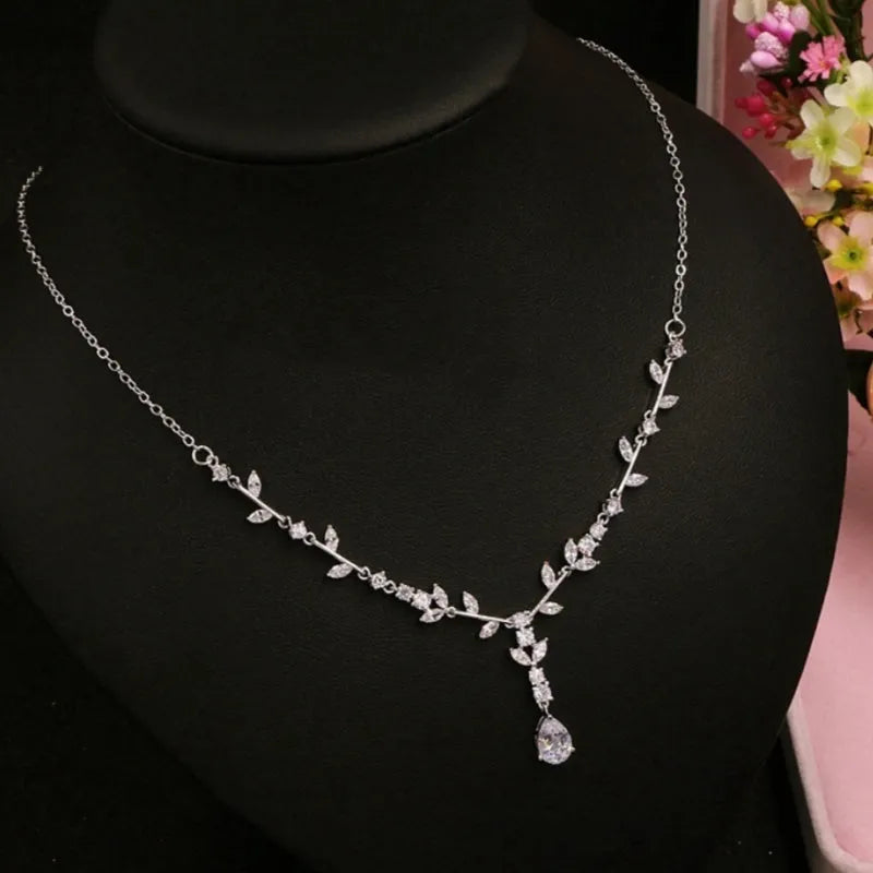 Simple bridal silver alloy love pattern necklace and earrings suite on display, handmade ornament set with ear clip option