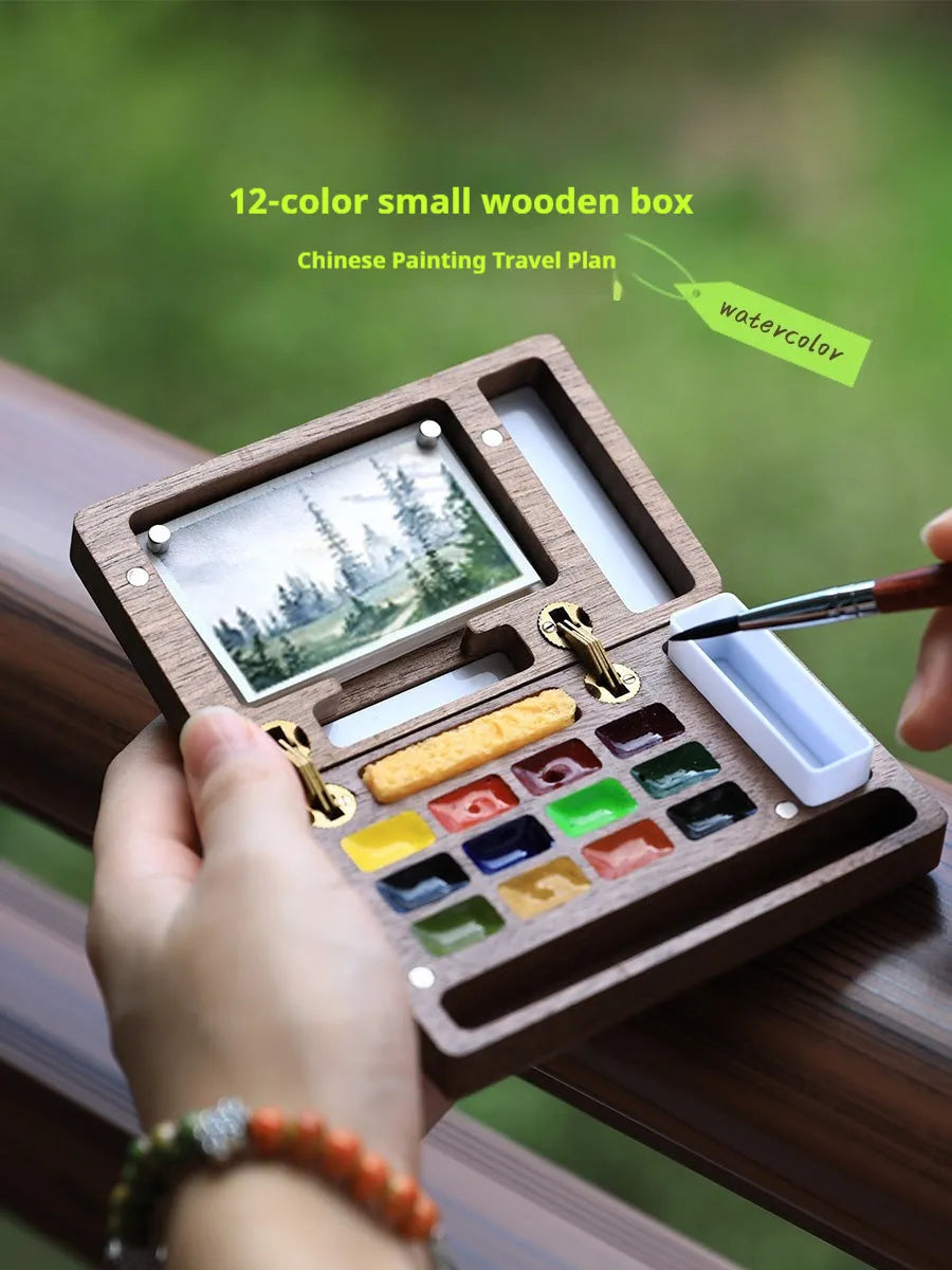 Mini walnut wood paint box open showing compartments for watercolour pigment pans.