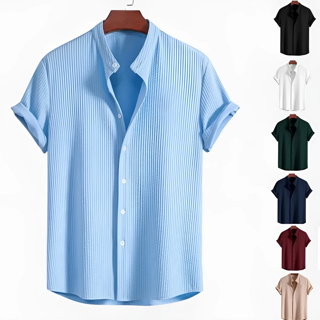 A man wearing a loose-fitting short sleeve casual shirt in a solid colour.