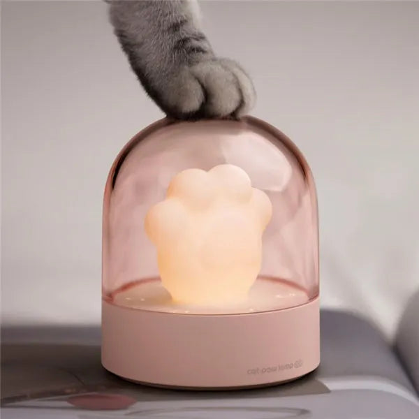 Grey cat paw shaped USB rechargeable musical night light on a wooden desk