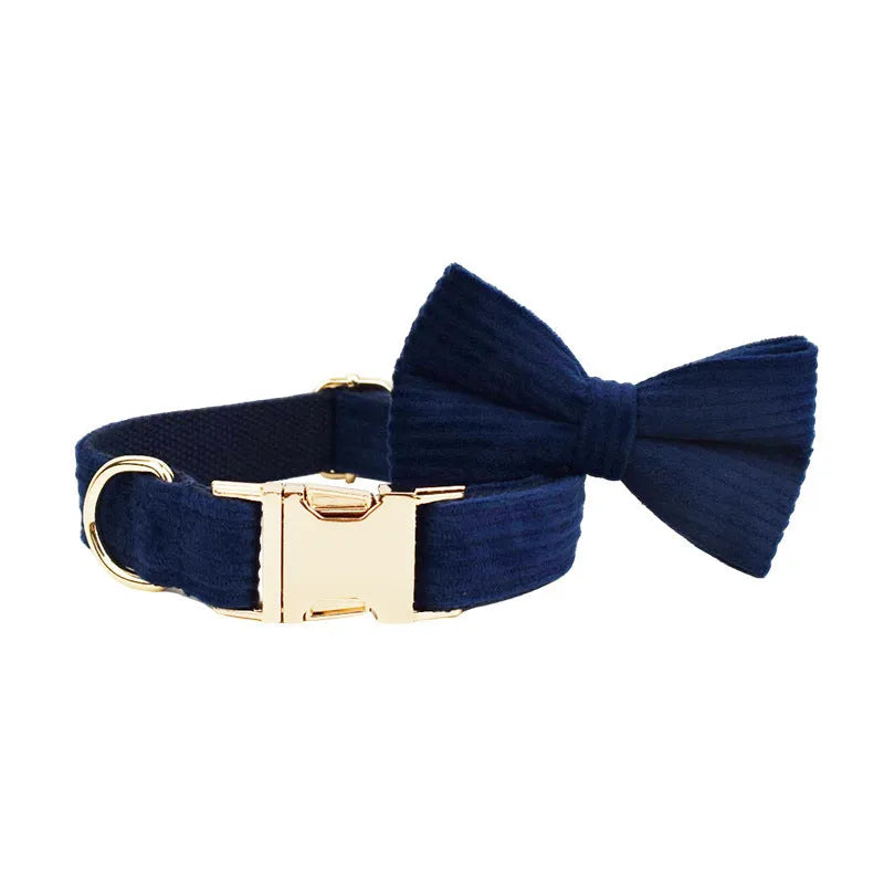 Navy blue corduroy dog collar and leash five-piece set with bow, vest, and poop bag on a wooden floor