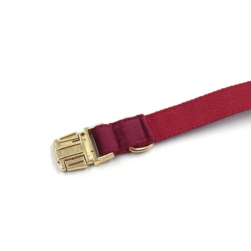 Burgundy velvet dog collar set with bow tie and leash on a wooden floor