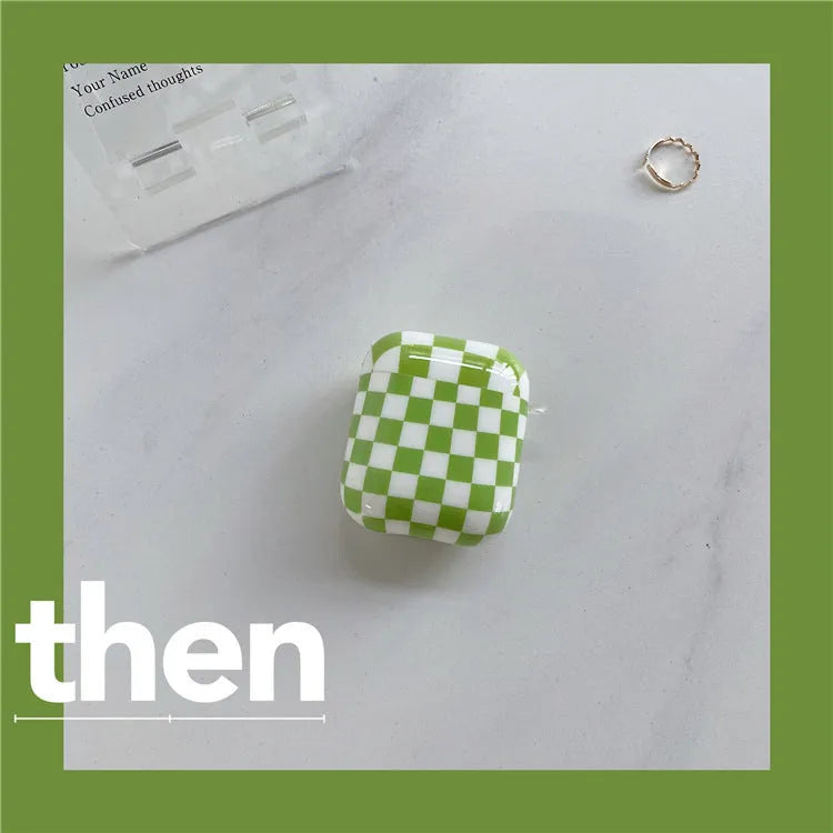 Black and green checkerboard pattern TPU protective case sleeves for Apple AirPods, one with a smiley face lanyard attached.