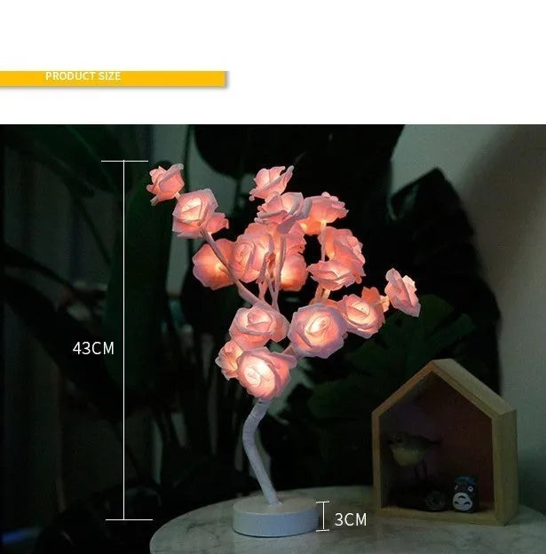 White and red rose flower LED table lamp with bonsai tree garland on a wooden table.