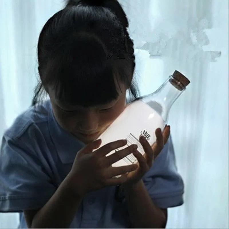 White milk bottle shaped LED nightlight on a wooden surface, USB rechargeable, with a 30-minute timer and DIY message panel
