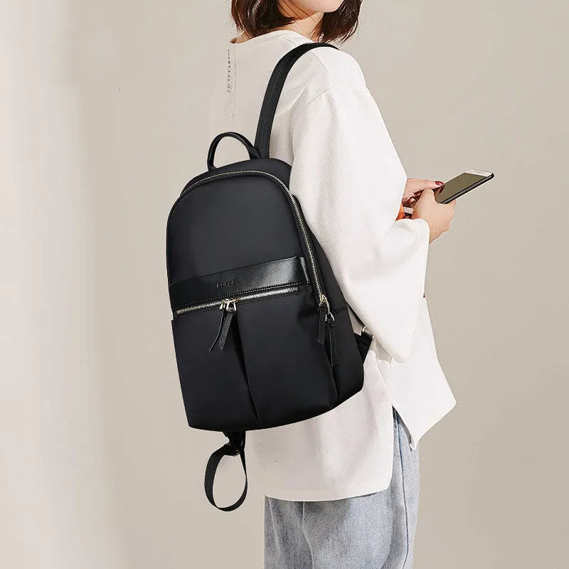 Women's black nylon backpack with zipper opening, internal computer sleeve, and phone pocket