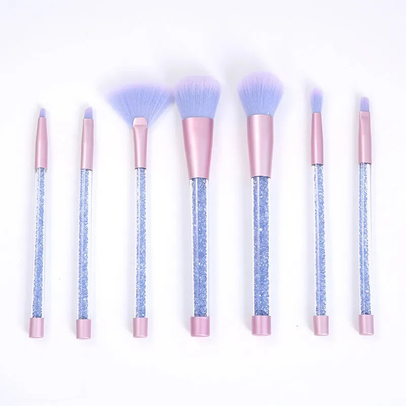 Set of 7 makeup brushes with pink handles, black bristles, and long plastic handles on a light background