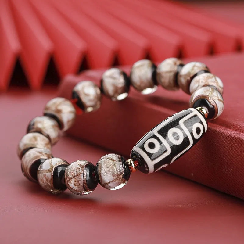 Close-up of a handcrafted coloured glaze bracelet with multi-colour lucky beads and auspicious Chinese patterns.