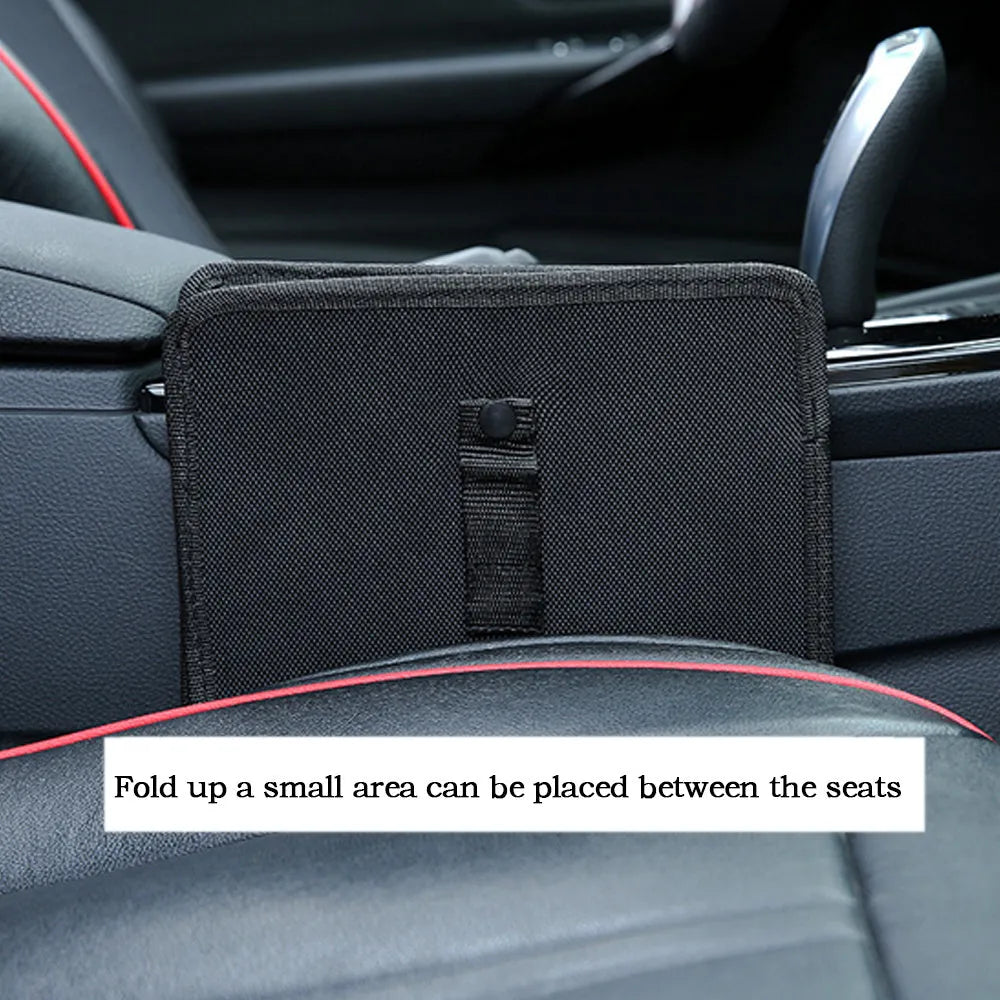 Foldable black Oxford car wastebasket with adjustable strap held on red seat headrest